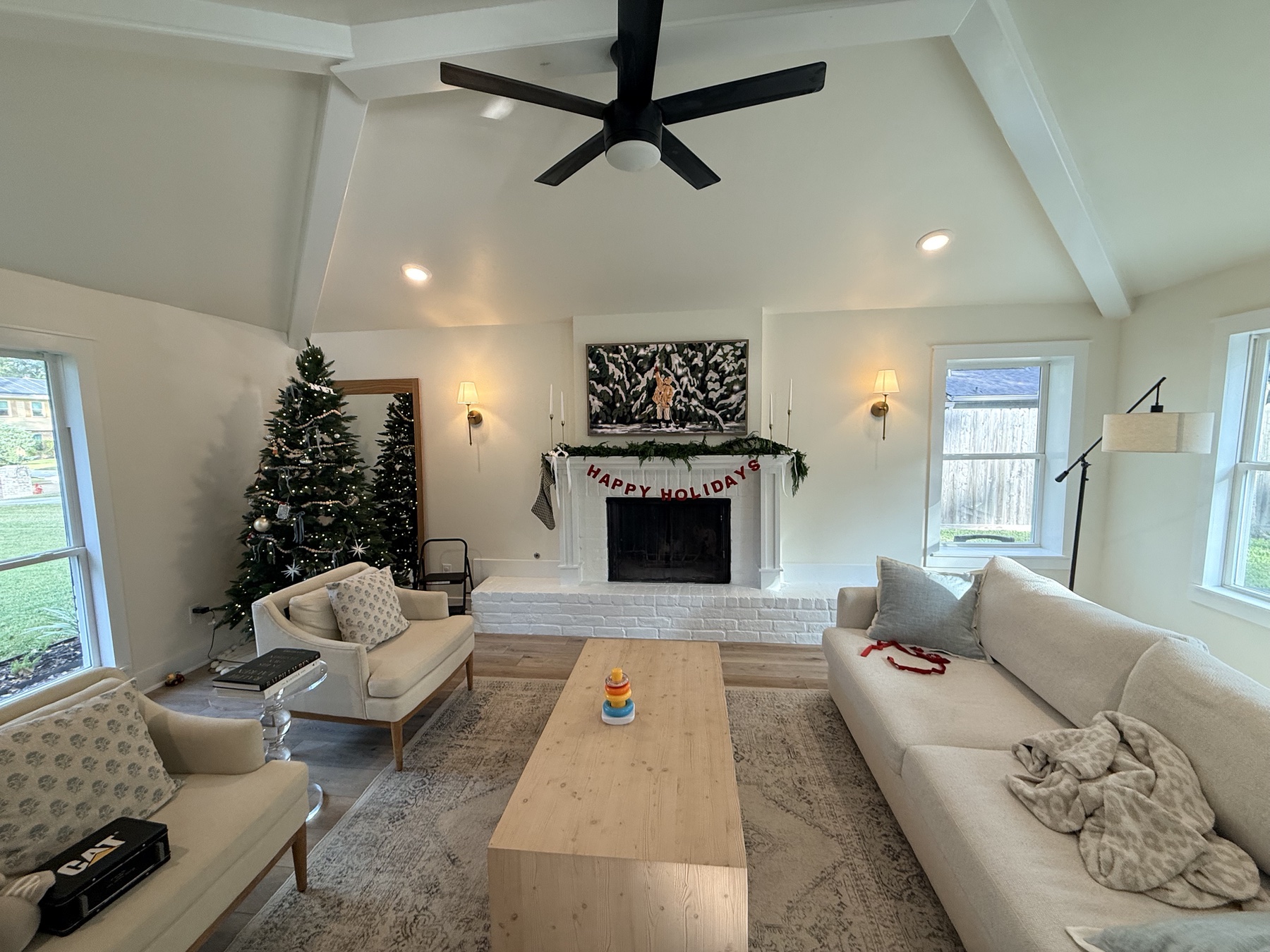 Completed Favorite Things living room with white fireplace mantel, custom window trim and complementary white finishes